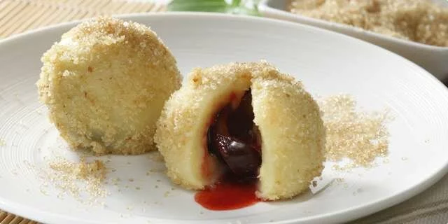 Dumplings with plums and baked bread crumbs and cinnamon