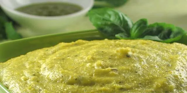 Polenta avec du fromage et la sauce à basilic